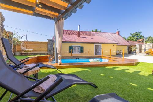 a yard with a swimming pool and a house at Old house Rustica with pool, jacuzzi and tavern - Valincic in Brinje