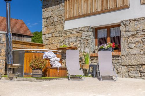 two chairs and a fountain in front of a house at Old house Rustica with pool, jacuzzi and tavern - Valincic in Brinje