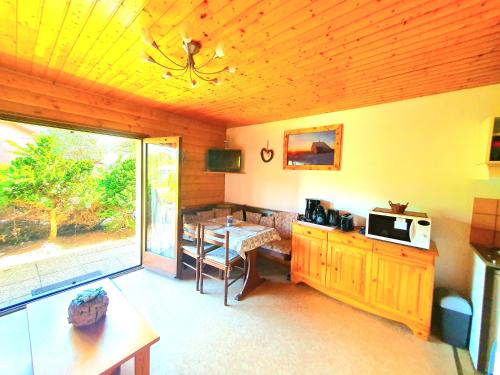 - un salon avec une table et un four micro-ondes dans l'établissement Appartement chalet avec chambre et terrasse, à Gérardmer