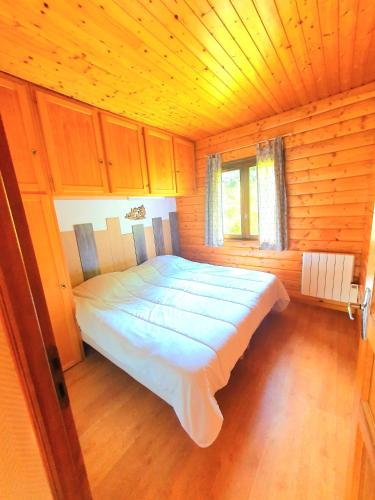 une chambre avec un lit dans une cabane en bois dans l'établissement Appartement chalet avec chambre et terrasse, à Gérardmer