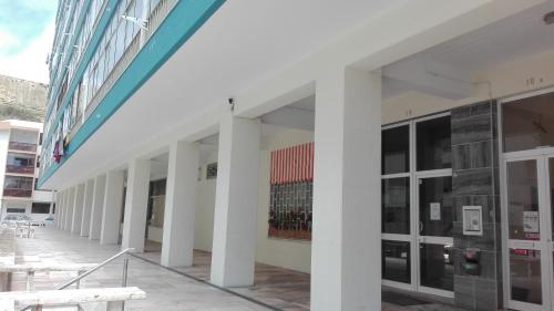 a building with white columns and windows and a bench at Lisbon Coast Flat in Quinta de Santo António