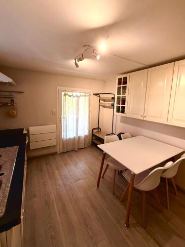 une cuisine avec une table et des chaises dans une pièce dans l'établissement Eaux Iris - Studio avec Jardin privatisé proche Casino, à La Roche-Posay