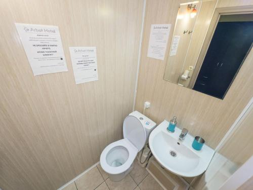 a bathroom with a white toilet and a sink at Semenovskiy Mini Hotel in Moscow
