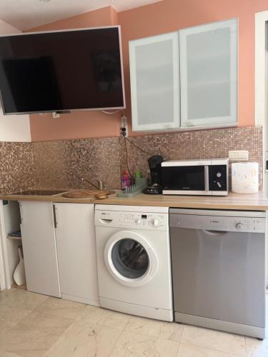 a kitchen with a washing machine and a microwave at La Villa Saint Jean BAS DE VILLA in La Ciotat