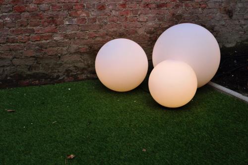 two eggs sitting on the grass next to a brick wall at Cadix 35 in Antwerp