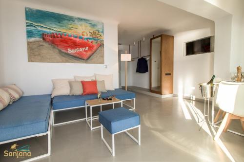 a living room with a blue couch and a painting at Santana Beach in Agia Anna Naxos