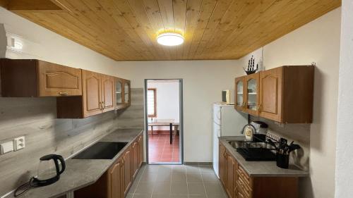 a kitchen with wooden cabinets and a refrigerator at Chata Brodský E1064 in Červený Kostelec