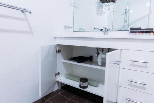 a bathroom with white cabinets and a sink at Scone Motor Inn & Apartments in Scone
