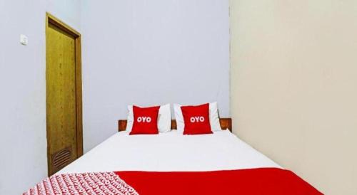 a bed with two red pillows in a room at OYO Life 92127 Skyland Pasteur in Bandung