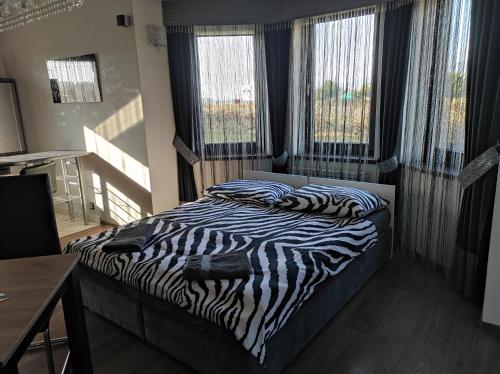 a zebra print bed in a bedroom with windows at Apartament Perła Pienin in Dębno