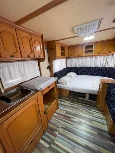 a kitchen with a sink and a bed in an rv at SEA CARAVAN ON THE BEACH in Kiten
