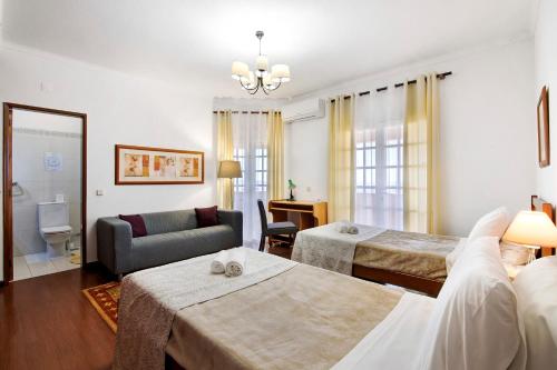 a hotel room with two beds and a couch at Quinta da Violeta in Loulé