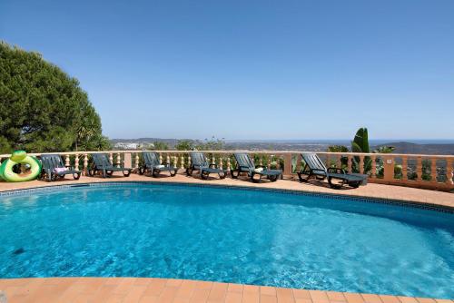 a large swimming pool with chairs on a balcony at Quinta da Violeta in Loulé