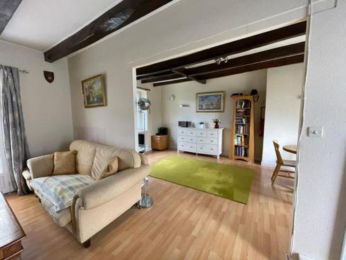 a living room with a couch and a green rug at House on La Basse Martinais in Saint-Vran