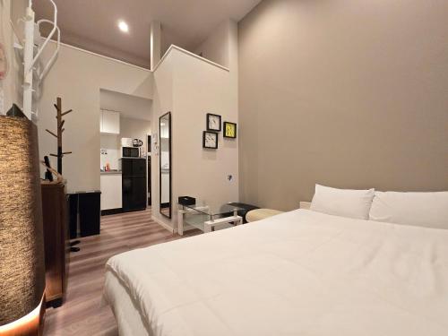 ein Schlafzimmer mit einem weißen Bett in einem Zimmer in der Unterkunft Comfort CUBE PHOENIX Yakuin in Susakiuramachi