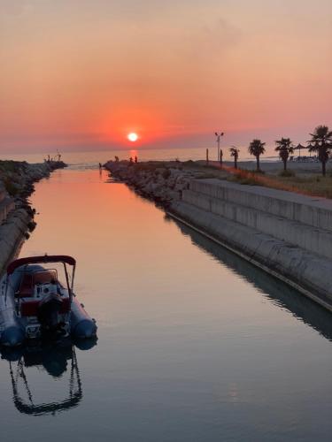 a boat in the water with a sunset in the background at Vala Mar Residence Shima in Draçi