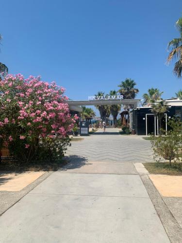 a parking lot with pink flowers in front of a building at Vala Mar Residence Shima in Draçi