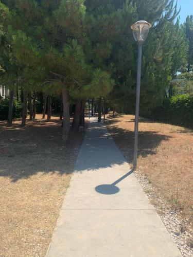 a sidewalk with a street light next to a park at Vala Mar Residence Shima in Draçi