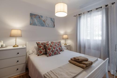 a bedroom with a white bed with towels on it at Tetuan 43 - Oasis Properties in Nerja