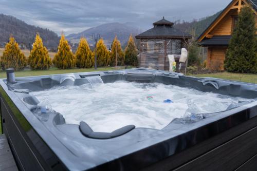 a jacuzzi tub with snow on top of it at Domki z bali na miedzy in Piwniczna