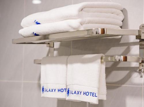 a towel rack with white towels in a bathroom at Galaxy Hotel Móng Cái in Móng Cái