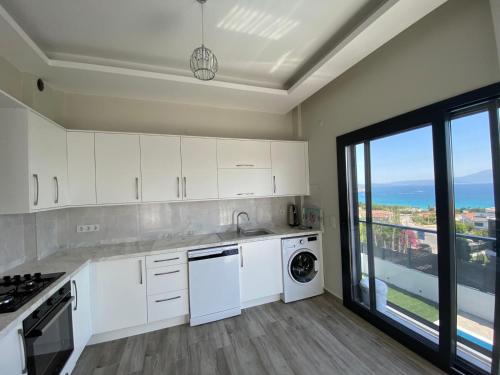 a kitchen with white appliances and a large window at Kaptan Villas in Cesme