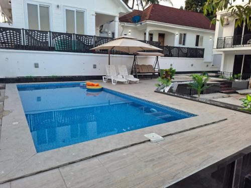 a swimming pool in front of a house at Serene BnB - Apt 08 Makongo after Mlimani City in Dar es Salaam