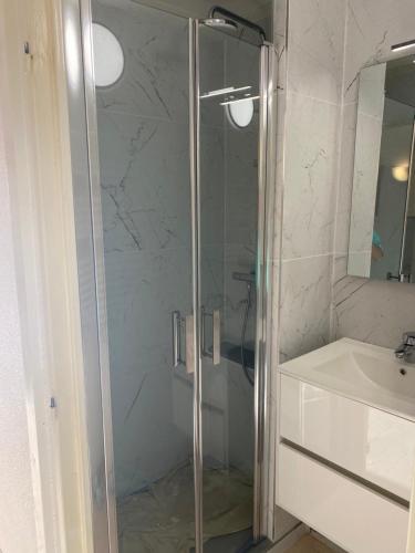 une douche avec une porte vitrée à côté d'un lavabo dans l'établissement Studio climatisé vue mer à proximité de la plage, à Saint-Raphaël