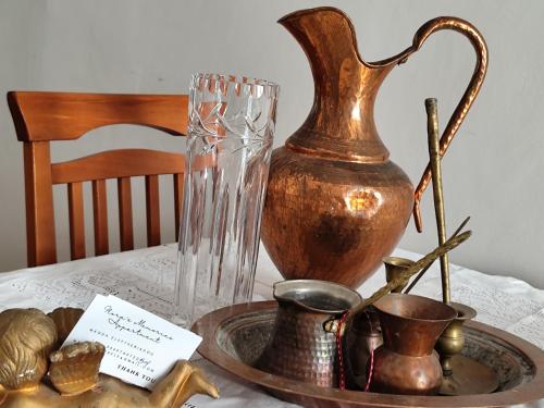 ein Tisch mit einer Vase und anderen Gegenständen darauf in der Unterkunft flora's memories appartment in Kavala