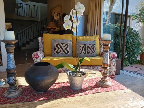 a living room with a yellow couch and a table at Tidal Retreat in Plettenberg Bay
