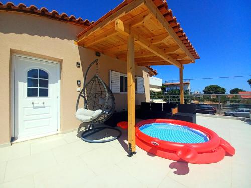 a patio with a swing and a swimming pool at ATHENS AIRPORT - SEASIDE STUDIO - Artemida in Artemida