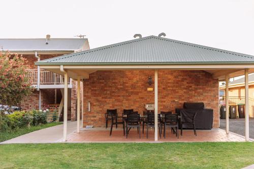 a pavilion with black chairs and tables in a yard at Scone Motor Inn & Apartments in Scone