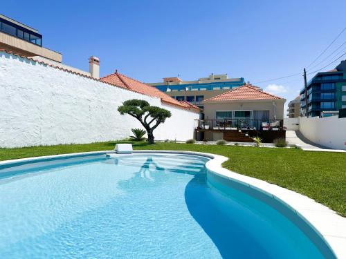 a swimming pool in front of a house at CASA dos SONHOS - SonhosQrodopiam in Praia da Barra