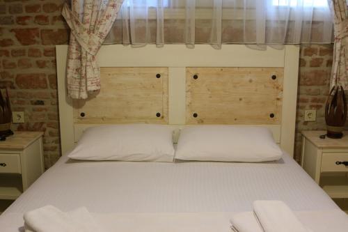 a bedroom with a white bed with a window at Gizemli Konak in Ayvalık