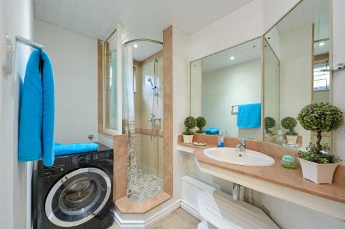 a bathroom with a washing machine and a sink at Ilot Bleu, beachfront flat, centre of Grand Baie in Grand Baie