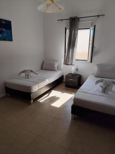 a room with two beds and a window at Beach View in Kaloi Limenes