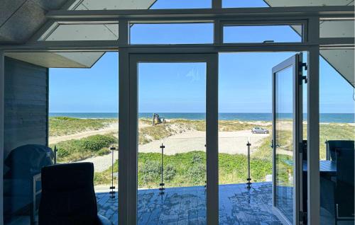 a room with sliding glass doors looking out at the ocean at Two-Bedroom Apartment In Thisted in Thisted
