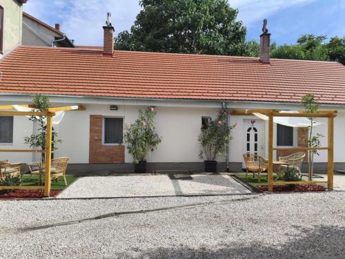 a white house with a red roof at KukoriQ 2 Apartman in Siklós
