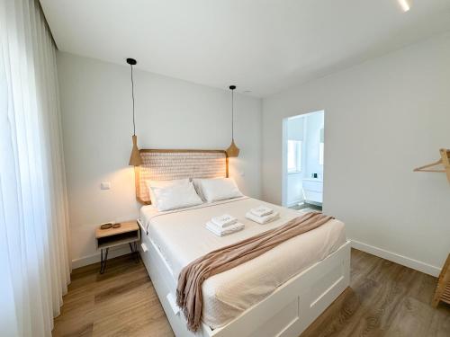 una camera da letto bianca con un letto grande e un tavolo di CASA dos SONHOS - SonhosQrodopiam a Praia da Barra