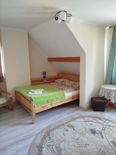 a bedroom with a bed with a green blanket at Przytulny kąt in Białowieża