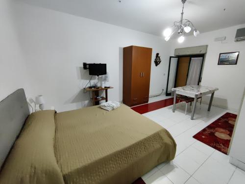 a bedroom with a bed and a table and a television at Casa Campus in Messina