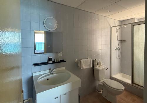 a white bathroom with a sink and a toilet at Hôtel A RENA D'ORU in Coggia