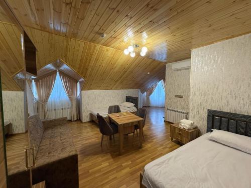 a bedroom with a table and a bed and a dining room at Sheki GuestHouse in Sheki