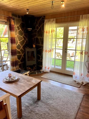 a living room with a table and sliding glass doors at Norwegian saunahouse in Haapse