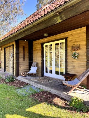 a wooden house with a rocking chair and a porch at Norwegian saunahouse in Haapse