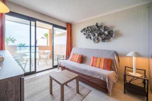 una sala de estar con un sofá y una mesa en Azuréa, vue mer avec ses 2 piscines, en Cannes