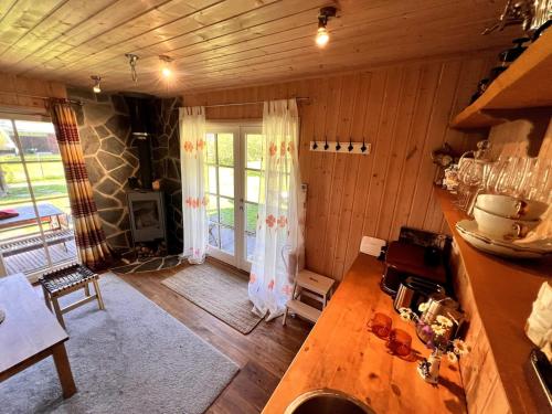 a kitchen with wooden walls and a room with a table at Norwegian saunahouse in Haapse