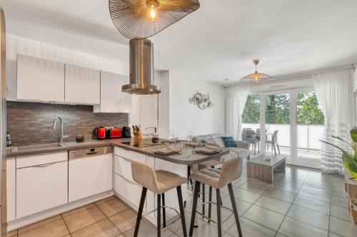 une cuisine avec des armoires blanches et une table et des chaises dans l'établissement Pur horizon, à Annecy