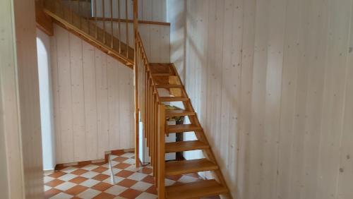 a wooden staircase in a room with a checkered floor at Prázdninový dům in Habří