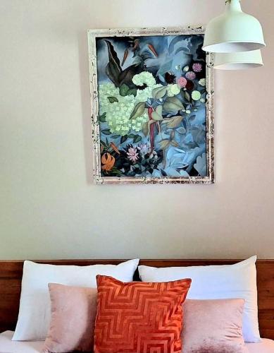 a painting on the wall above a bed with pillows at Self check-in spacious apartment in a quiet area in Rīga